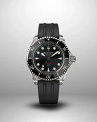 Navanos Ravaro Swiss automatic dive watch with black dial, cream luminous markers and hands, red "Ravaro" script, black ceramic unidirectional bezel, 300m water resistance, COSC-certified Soprod P024 movement, sapphire crystal, and matching black FKM rubber strap, studio shot on light gray background.