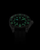 Navanos Ravaro Swiss automatic dive watch in complete darkness with powerful green Super-LumiNova lume fully illuminating the black dial, markers, hands, trident logo, and bezel pip, paired with black FKM rubber strap, 300m water resistance, COSC-certified Soprod P024 movement, angled studio lume shot on black background.