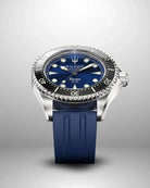 Navanos Ravaro Swiss automatic dive watch with blue sunburst dial, cream luminous markers and hands, black ceramic unidirectional bezel, 300m water resistance, COSC-certified Soprod P024 movement, sapphire crystal, and matching navy blue FKM rubber strap, angled studio shot on light gray background.