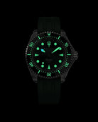Navanos Ravaro Swiss automatic dive watch in complete darkness with powerful green Super-LumiNova lume fully illuminating the dial, markers, hands, trident logo, and bezel pip, paired with a green FKM rubber strap, 300m water resistance, COSC-certified Soprod P024 movement, studio lume shot on black background.
