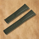 Luxury piton green sailcloth watch strap featuring curved ends, padding, and adjustment holes.